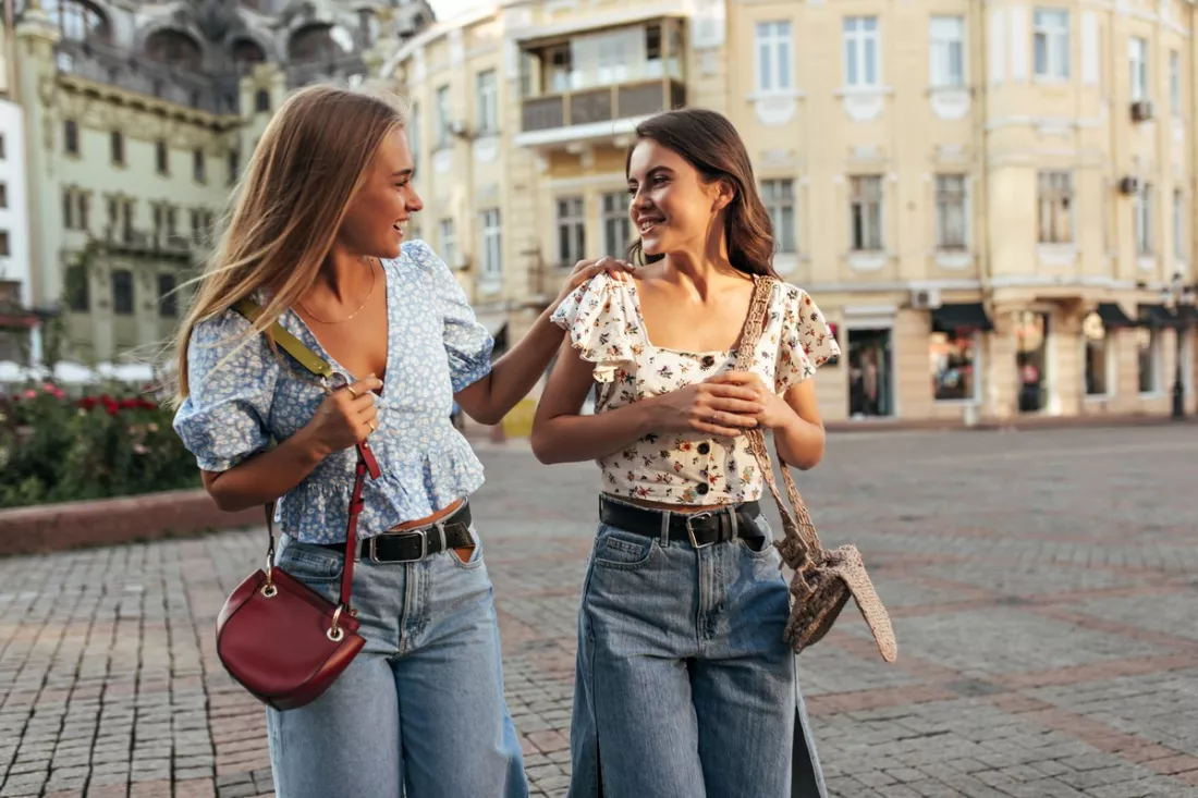 Two friends walking across a city square
