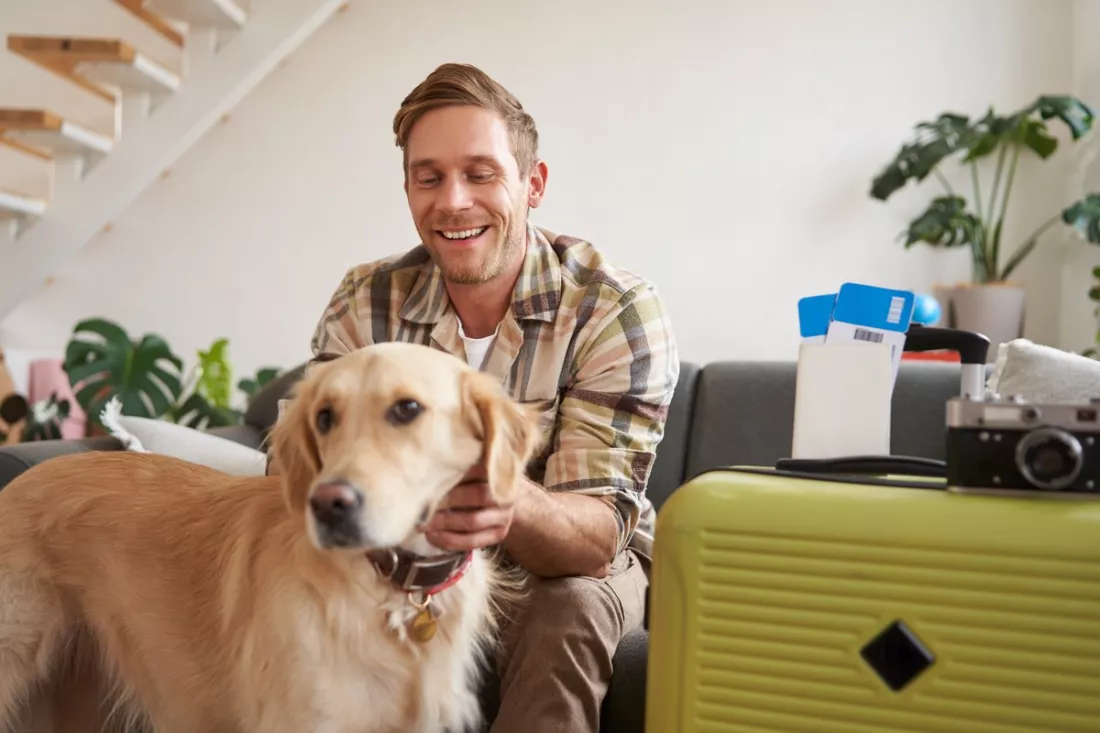 A young man with his dog, packing for a trip